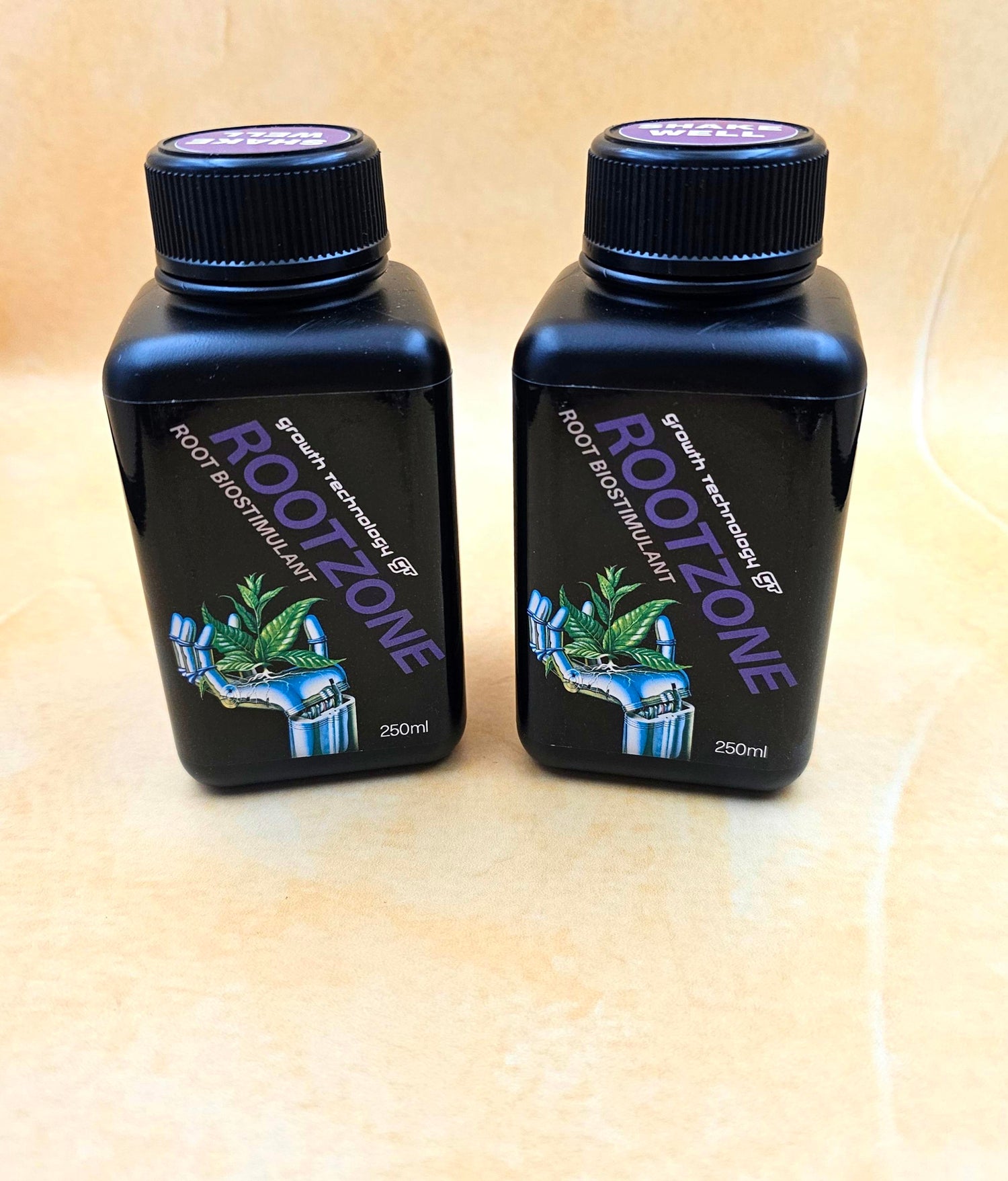 Two bottles of Rootzone root stimulant on a beige surface
