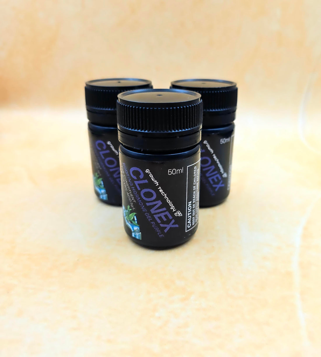 Three Clonex containers on a beige surface